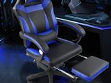 un gros plan d'un fauteuil de gaming muni d'un repose-pieds, devant un écran