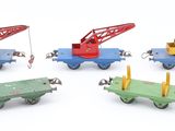 four toy trains with a crane on each of them