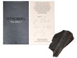 an open book sitting next to a piece of paper and a piece of wood