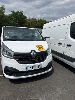 two white vans parked in a parking lot next to each other