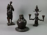 three bronze figurines that are sitting on a table