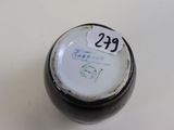 a close up of a black and white vase with a label on it