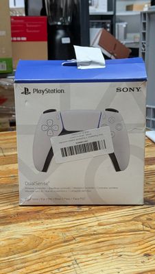 La boîte de la manette PlayStation est posée sur la table.