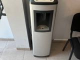 a water dispenser next to a chair in a room