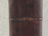 un étui en cuir marron posé sur une table blanche