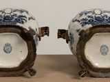 pair of blue and white vases with handles on a table