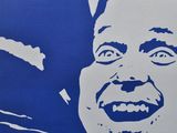 a blue poster with a picture of a smiling man