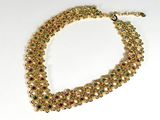 une photo d'un collier en or orné de pierres multicolores