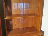 a wooden bookcase with a glass door on it