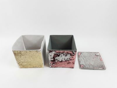 trois boîtes carrées ornées de paillettes argentées, roses et dorées
