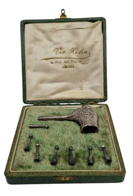 un vieil ensemble d'outils en métal dans un coffret vert sur fond blanc