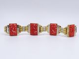 two gold and red cufflinks with red crystals on them