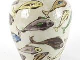 un vase blanc orné d'un motif de poissons