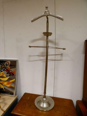 a metal object on a wooden table next to a painting