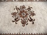 a white rug with a brown flower design on it