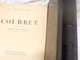 un livre posé sur une table, à côté de deux vieux livres