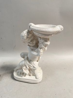 une statue représentant une femme tenant un bol sur la tête