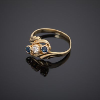 a close up of a gold ring with blue and white stones