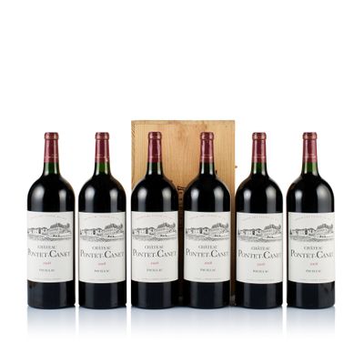 four bottles of red wine sit in front of a wooden box
