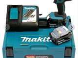 un gros plan d'une perceuse sans fil et d'une batterie posées sur une boîte à outils