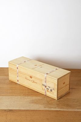 une boîte en bois posée sur une table en bois, avec un mur blanc en arrière-plan