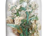 a glass clochet with a vase of flowers inside of it