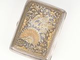 an antique silver and gold cigarette case with a floral design