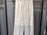 un pantalon blanc suspendu à un portant dans une pièce