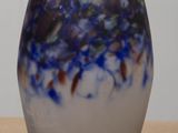a blue and white vase sitting on top of a wooden table