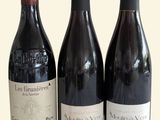 trois bouteilles de vin sont alignées sur une surface blanche