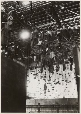 an old black and white photo of a bunch of clothes hanging from a ceiling