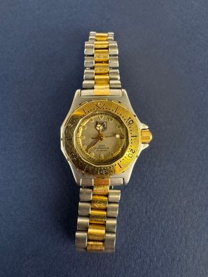 un gros plan d'une montre posée sur une table, sur fond bleu