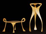 two wooden chairs and a table in a dark room