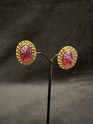 pair of gold and pink stone earrings on a stand