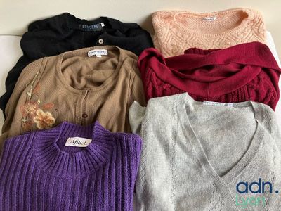 several sweaters are stacked on top of each other on a table