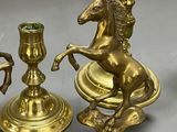 three candles and a candelab with a horse on it