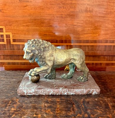 une statue de lion posée sur un socle en marbre