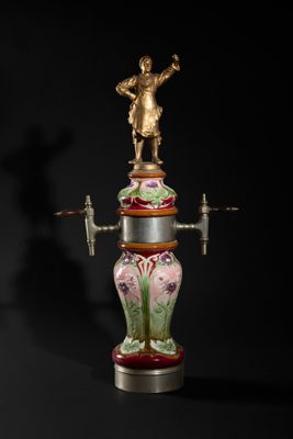 a vase with a statue on top of it on a black background