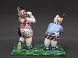 two figurines of a man and a woman playing golf
