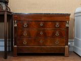 a small chest of drawers next to a small table