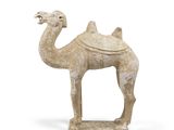 une vieille statue représentant un chameau avec une selle sur le dos
