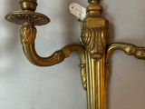 pair of antique brass wall sconces with two candles on them
