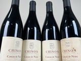 four bottles of wine are lined up on a table