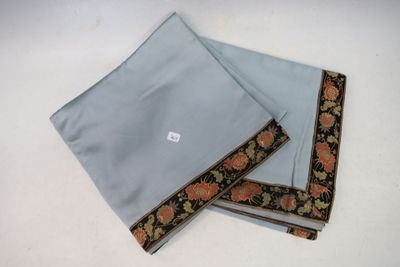two pieces of blue cloth with orange and black flowers on them