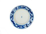 une assiette bleue et blanche posée sur un fond blanc