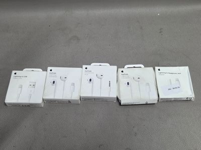 trois boîtes d'écouteurs blancs posées les unes à côté des autres sur une table