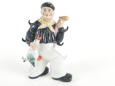 une figurine représentant un homme tenant un poisson et un oiseau