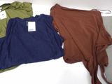 three different colored shirts on a white table with a hanger
