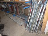 many skis and ski poles stacked up in a room