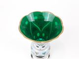 un vase en verre vert avec un bord doré sur fond blanc